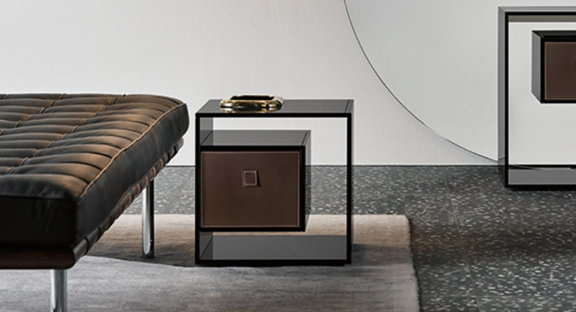 LIBER BEDSIDE TABLE – Modern glass bedside table with a leather drawer, resting on a mirrored base. By Tonelli Design.
